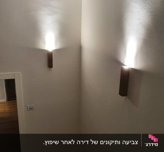 קיר צבוע בלבן עם תאורה עליונה